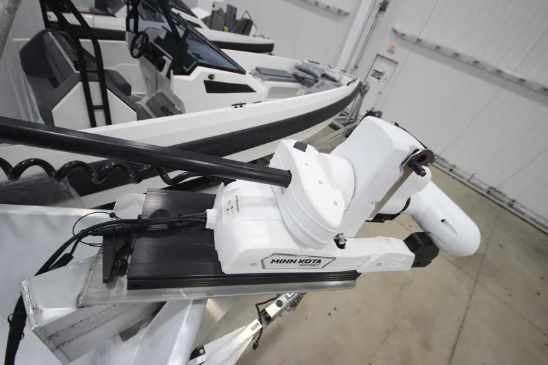 Slide: The Image of 2025 Weldcraft 300 Cuddy King OS with Minn Kota motor in a garage setting. - 46