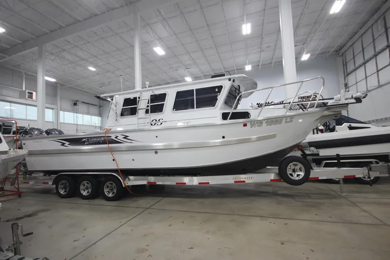 The Image of 2025 Weldcraft 300 Cuddy King OS boat on custom 15k trailer in indoor showroom. - 1