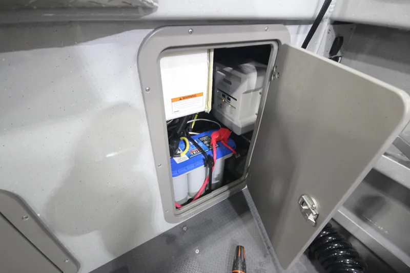 Slide: The Image of Open compartment in 2025 Weldcraft 300 Cuddy King OS, showing battery and wiring. - 14
