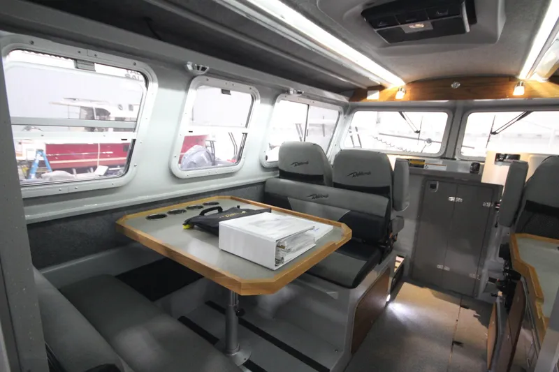 Slide: The Image of Interior of 2025 Weldcraft 300 Cuddy King OS, featuring seating and table. - 21