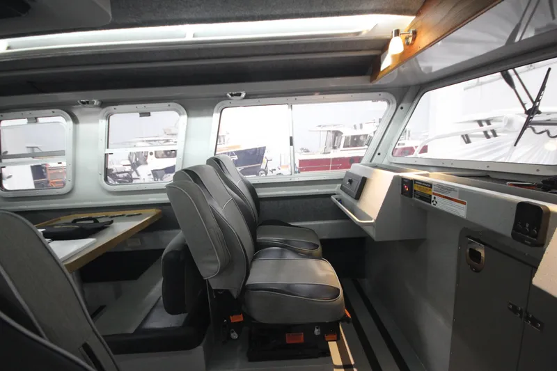 Slide: The Image of 2025 Weldcraft 300 Cuddy King OS interior with seating and control panel. - 27