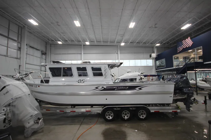 Slide: The Image of 2025 Weldcraft 300 Cuddy King OS boat on custom 15k trailer in showroom. - 3