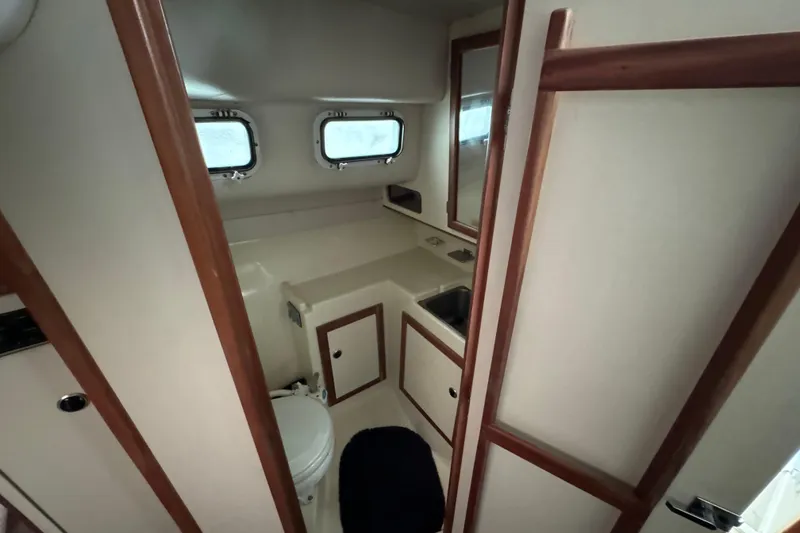 Slide: The Image of 1999 Albin 28 Tournament Express bathroom with sink, toilet, and wooden accents. - 11