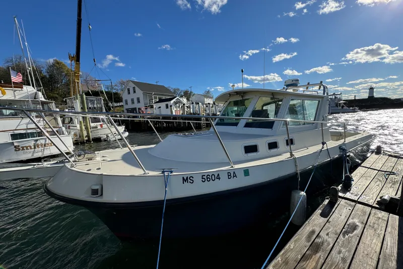 Slide: The Image of 1999 Albin 28 Tournament Express docked at a marina under a clear blue sky. - 3