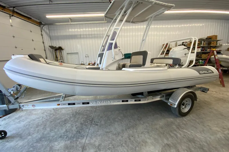 Slide: The Image of 2026 Gala V500 inflatable boat on trailer in a garage setting. - 6