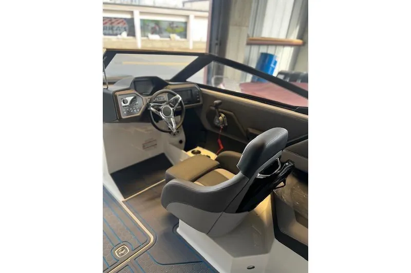 Slide: The Image of 2025 Cobalt CS23 Surf boat interior with modern steering and dashboard design. - 11