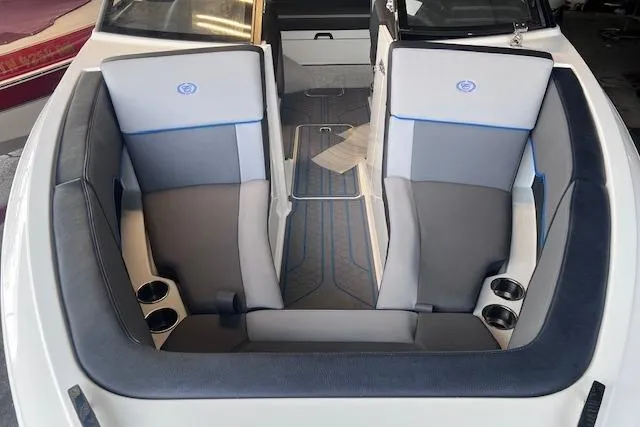 Slide: The Image of 2025 Cobalt CS23 Surf boat interior with gray and blue seating, cup holders, and modern design. - 2