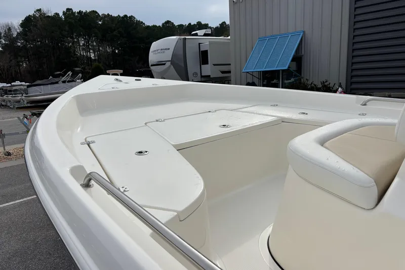 Slide: The Image of 2026 Bulls Bay 2000 boat with white seating, parked near RVs and trees. - 7