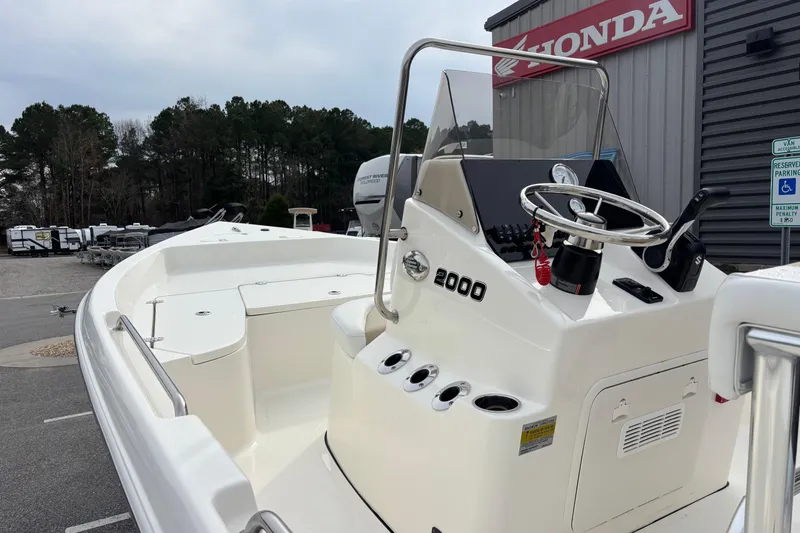 Slide: The Image of 2026 Bulls Bay 2000 boat with steering console, parked near Honda dealership. - 9