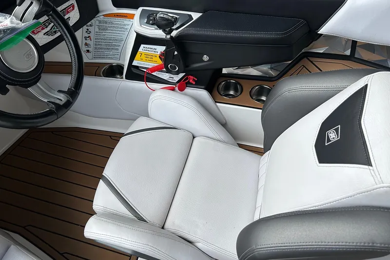 Slide: The Image of 2019 Nautique Ski Nautique interior with steering wheel, controls, and white seating. - 16