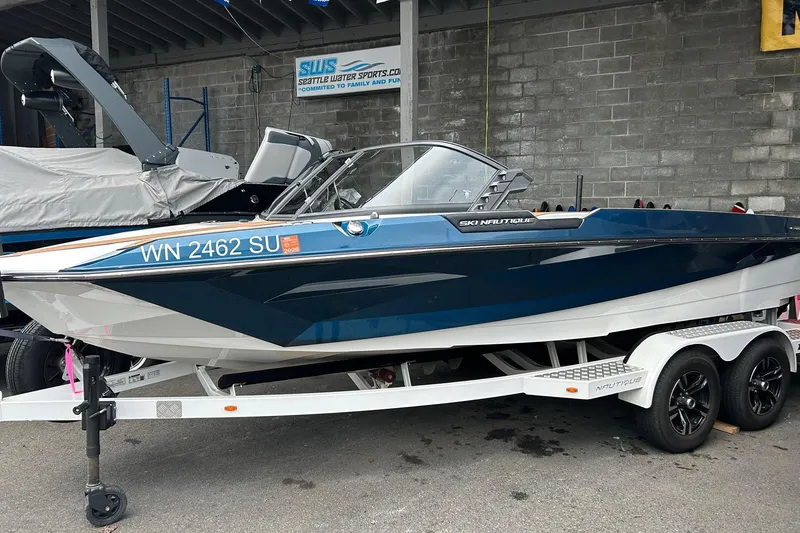 Slide: The Image of 2019 Nautique Ski Nautique boat on trailer, blue and white design, parked at Seattle Water Sports. - 2