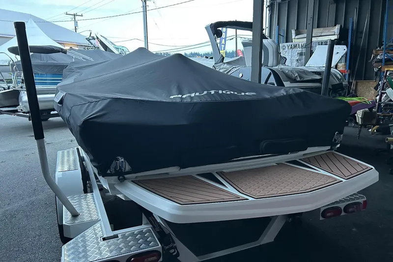Slide: The Image of 2019 Nautique Ski Nautique boat covered, parked on a trailer in a storage area. - 28