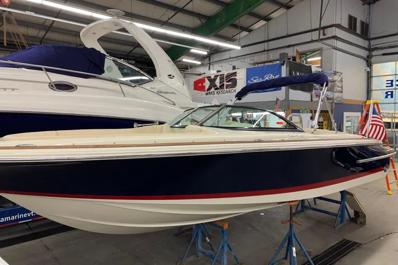 The Image of 2018 Chris-Craft Launch 23 boat displayed indoors on stands. - 1