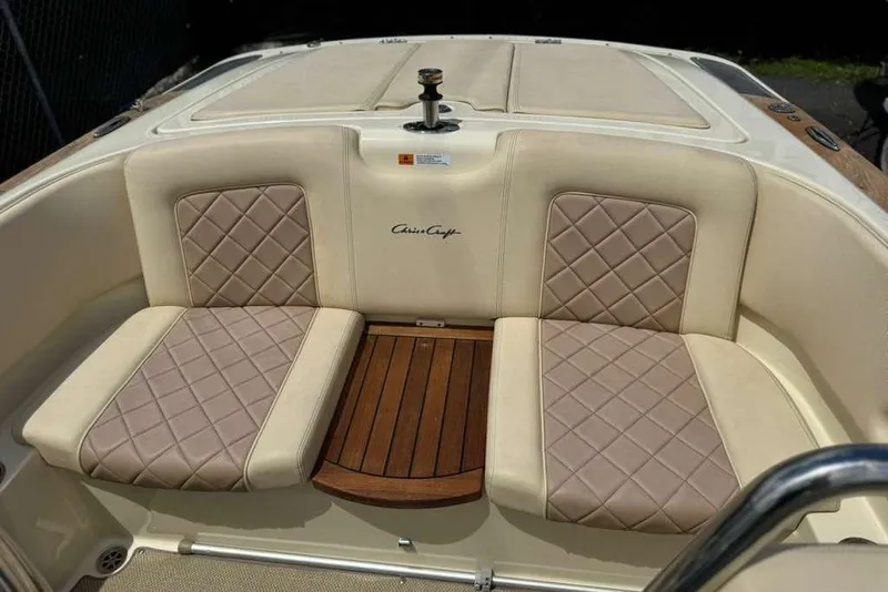 Slide: The Image of 2018 Chris-Craft Launch 23 boat interior with beige quilted seats and wooden accents. - 18