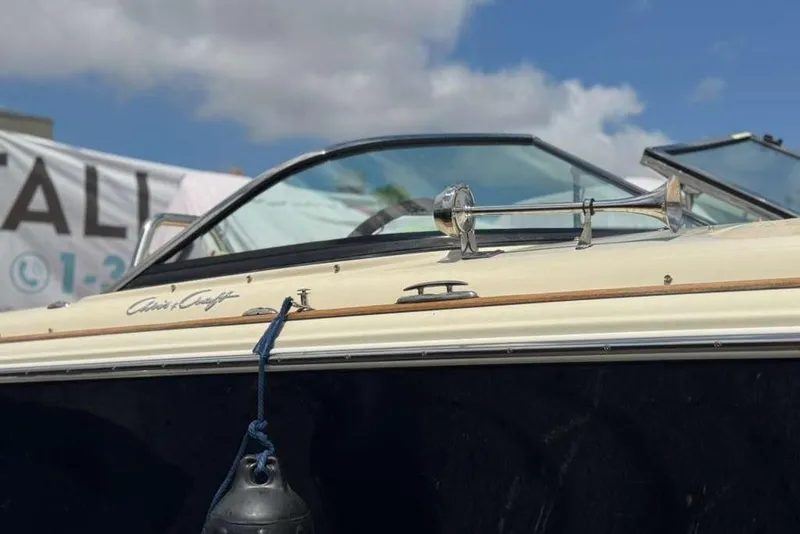 Slide: The Image of 2018 Chris-Craft Launch 23 boat with sleek design and chrome details under a blue sky. - 20