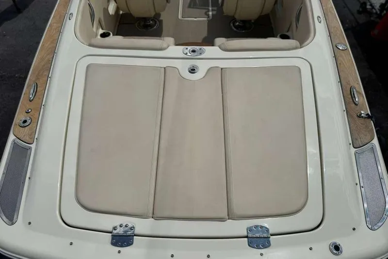 Slide: The Image of 2018 Chris-Craft Launch 23 boat interior with beige seating and wooden accents. - 25
