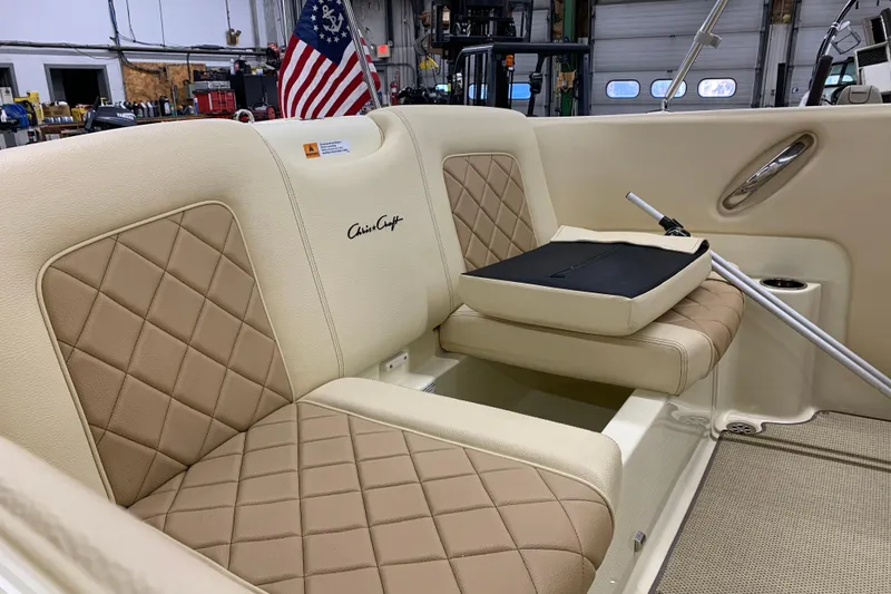 Slide: The Image of 2018 Chris-Craft Launch 23 interior with beige diamond-stitched seats and American flag. - 8