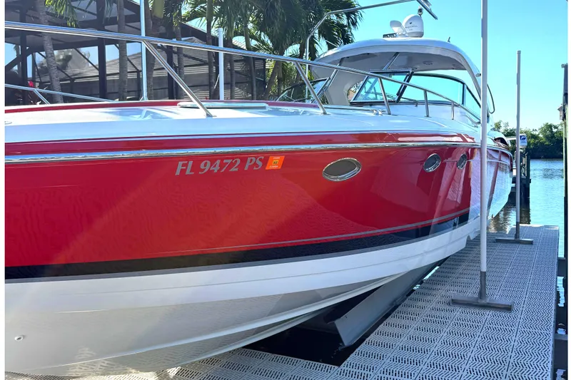 The Image of 2015 Formula 400 Super Sport boat docked, red and white exterior, sunny day, palm trees in background. - 0