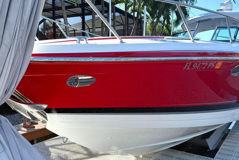 Slide: The Image of 2015 Formula 400 Super Sport boat docked, red and white exterior, surrounded by palm trees. - 2