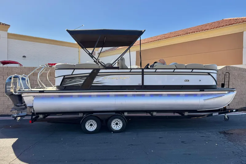 The Image of 2021 Starcraft SLS 3 pontoon boat on trailer, featuring a Yamaha engine and canopy. - 0