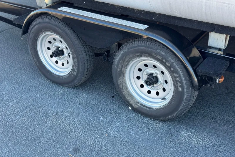 Slide: The Image of 2021 Starcraft SLS 3 trailer wheels on asphalt surface. - 31