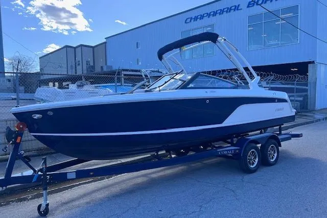 Slide: The Image of 2025 Cobalt CS23 Surf boat on trailer outside Chaparral Boats building. - 2