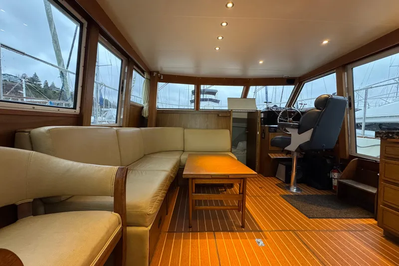 Slide: The Image of 1974 Tollycraft 40 Tri-Cabin MY interior with beige seating, wooden flooring, and helm station. - 8