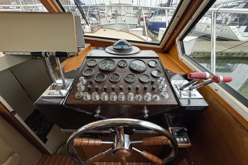 Slide: The Image of 1974 Tollycraft 40 Tri-Cabin MY helm with gauges and controls in a marina setting. - 11