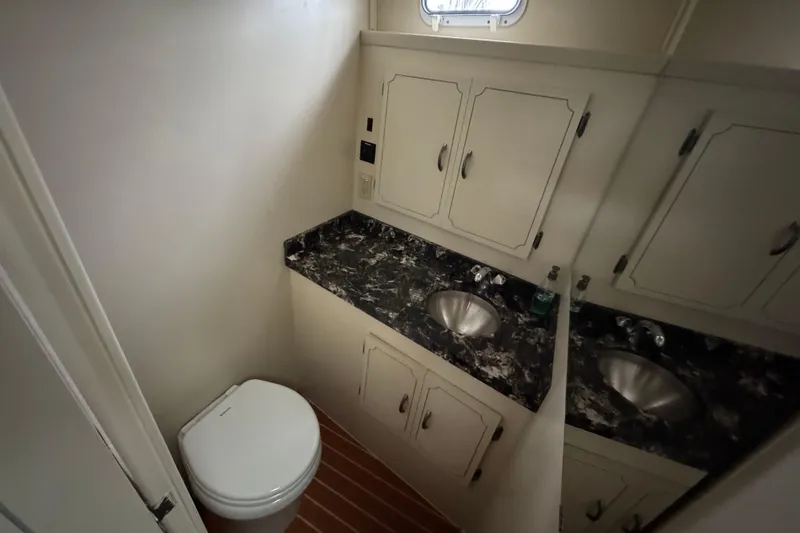 Slide: The Image of 1974 Tollycraft 40 Tri-Cabin MY bathroom with marble countertop and stainless steel sink. - 16