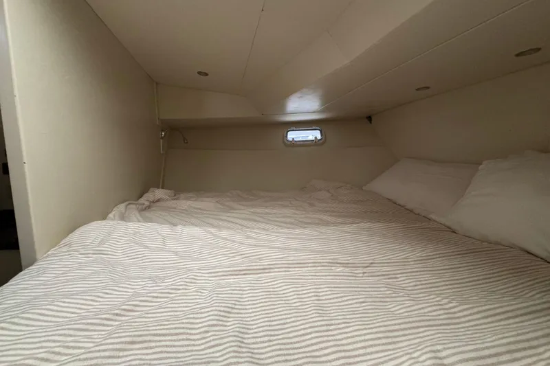 Slide: The Image of Cozy cabin bed inside 1974 Tollycraft 40 Tri-Cabin MY yacht, featuring striped bedding. - 19