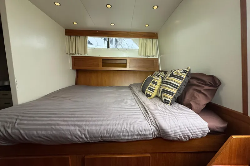 Slide: The Image of 1974 Tollycraft 40 Tri-Cabin MY bedroom with cozy bed and striped pillows. - 4