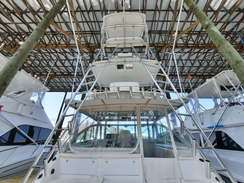 Slide: The Image of Cabo 45 Express 2000 under covered dock, front view. - 12