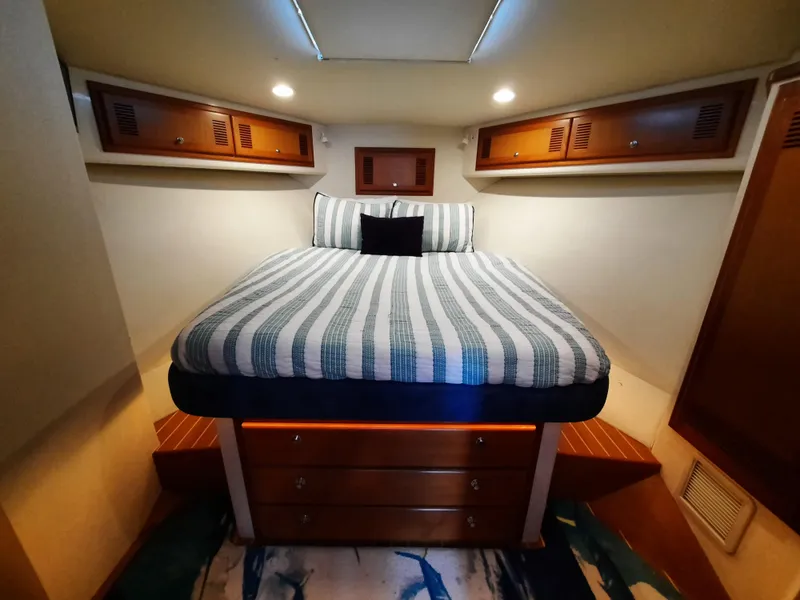 Slide: The Image of Interior of 2000 Cabo 45 Express with cozy bed and wooden cabinets. - 29
