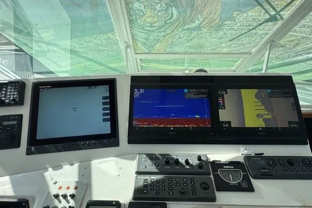 Slide: The Image of Control panel of a 2000 Cabo 45 Express boat with navigation screens and controls. - 6