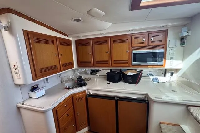 Slide: The Image of 2000 Cabo 45 Express yacht kitchen with wooden cabinets and modern appliances. - 60