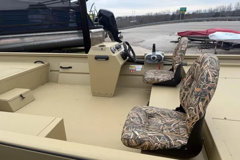 Slide: The Image of 2026 Lowe Roughneck 2070SC boat interior with camo seats and steering console. - 8
