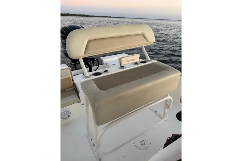 Slide: The Image of 2014 Pathfinder 2200 TRS boat seat with rod holders, on calm water at sunset. - 12