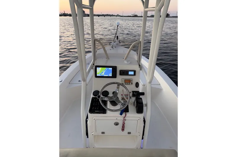 Slide: The Image of 2014 Pathfinder 2200 TRS boat console with navigation equipment at sunset on the water. - 15