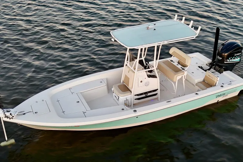Slide: The Image of 2014 Pathfinder 2200 TRS boat on calm water, featuring a sleek design and Yamaha engine. - 28