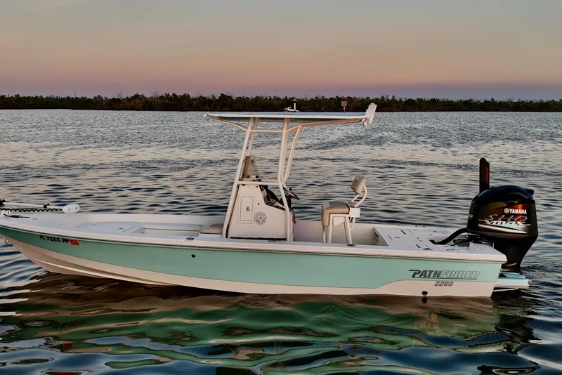 Slide: The Image of 2014 Pathfinder 2200 TRS boat on calm water at sunset, featuring Yamaha outboard motor. - 40