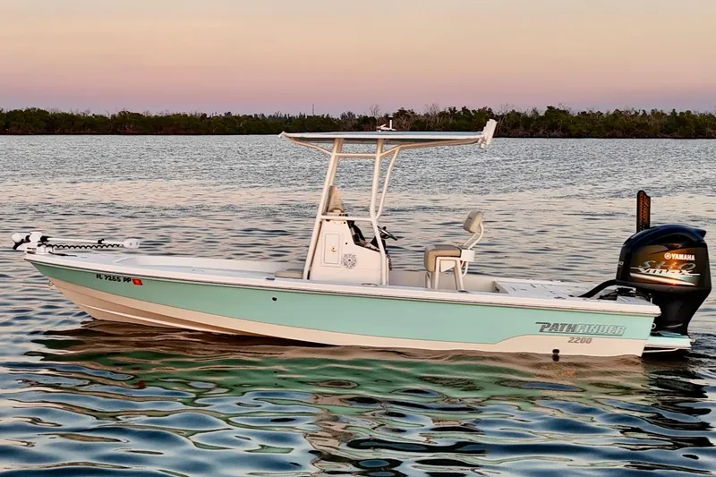 Slide: The Image of 2014 Pathfinder 2200 TRS boat on calm water at sunset with Yamaha engine. - 43