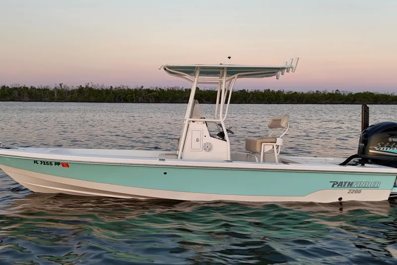 Slide: The Image of 2014 Pathfinder 2200 TRS boat on calm water at sunset. - 44