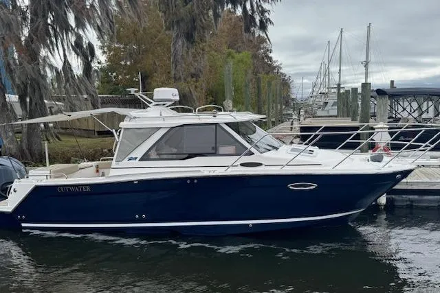 Slide: The Image of 2026 Cutwater C-248 Coupe boat on trailer, parked outdoors under clear blue sky. - 1