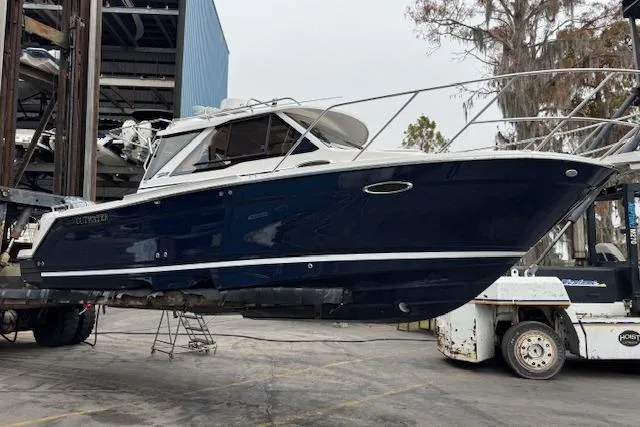 Slide: The Image of 2026 Cutwater C-248 Coupe boat docked on a calm waterfront. - 2