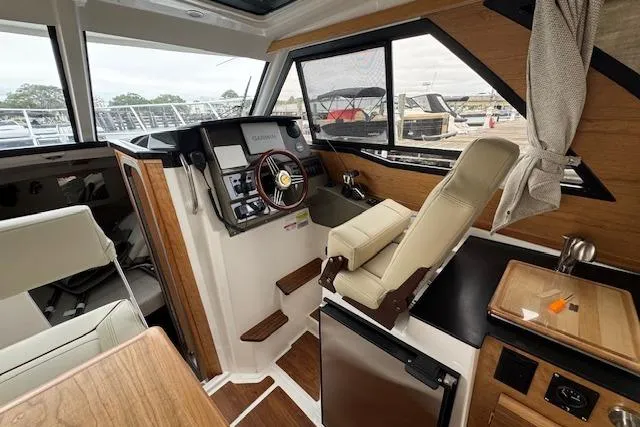 Slide: The Image of 2026 Cutwater C-248 Coupe interior with wooden table and seating, dock view. - 27