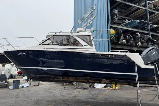 Slide: The Image of 2026 Cutwater C-248 Coupe boat in dry dock, blue hull, side view. - 5