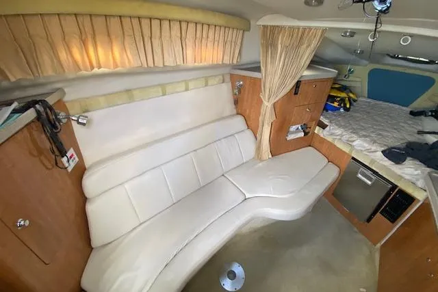 Slide: The Image of 2004 Regal Commodore 2860 cabin interior with seating, bed, and kitchenette. - 11