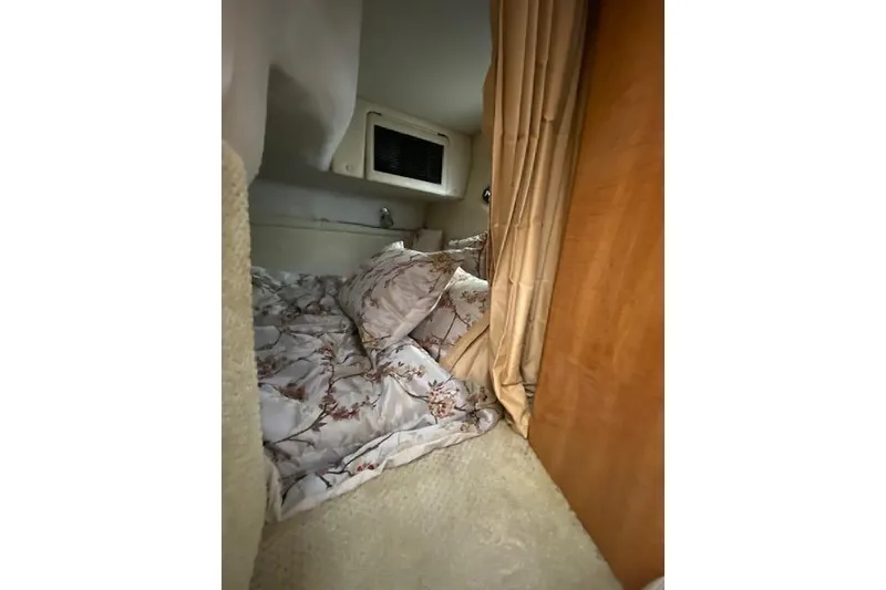 Slide: The Image of Cozy cabin interior of 2004 Regal Commodore 2860 with floral bedding and wooden accents. - 13