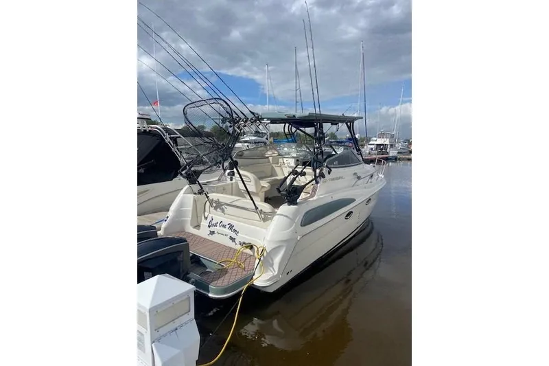 Slide: The Image of 2004 Regal Commodore 2860 boat docked, equipped with fishing gear under cloudy skies. - 2