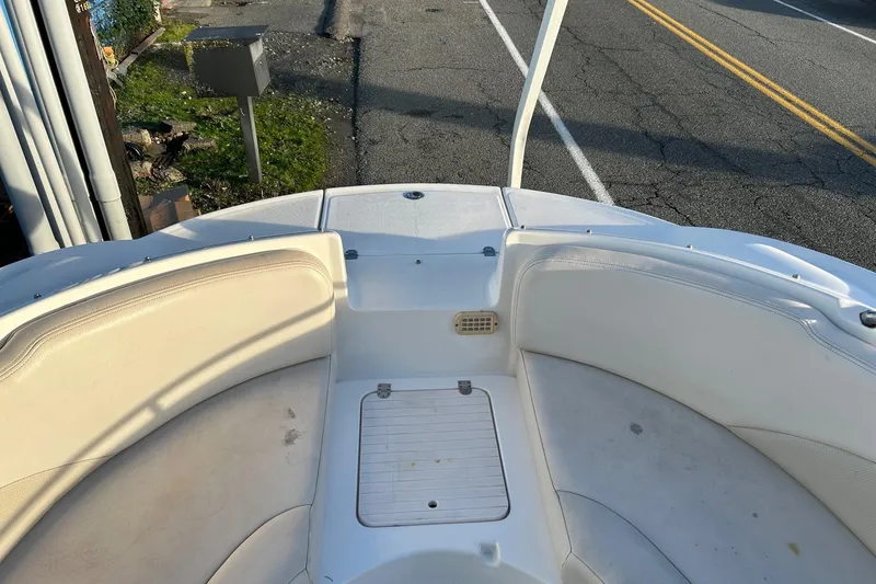 Slide: The Image of 2005 Chaparral Sunesta 252 boat interior with white seating and storage compartment. - 12